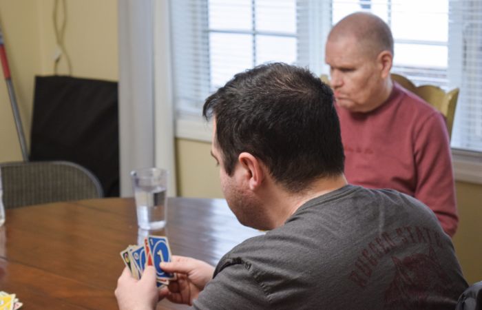 two adults with idd playing uno card game
